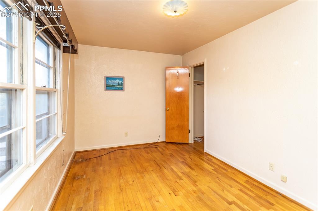 Image 8 of 24: Spare room with light wood-type flooring and baseboards