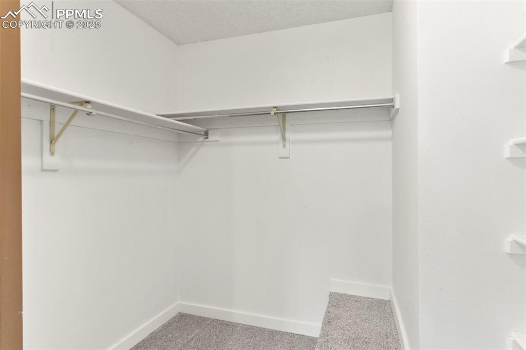 Image 13 of 24: Walk in closet with carpet