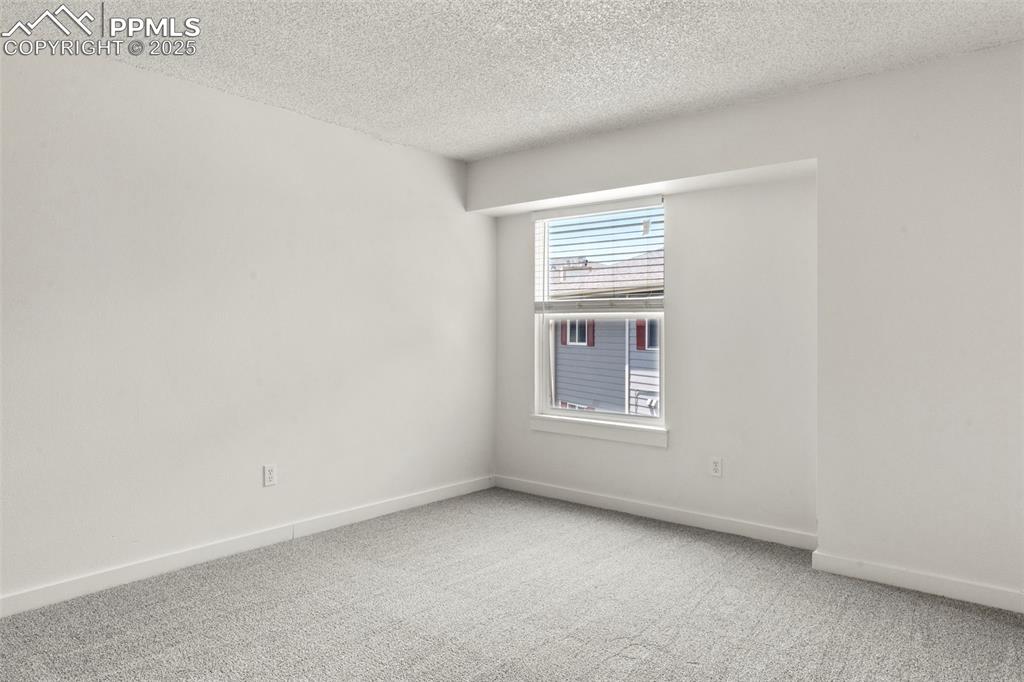 Image 15 of 24: Unfurnished room with carpet flooring and a textured ceiling
