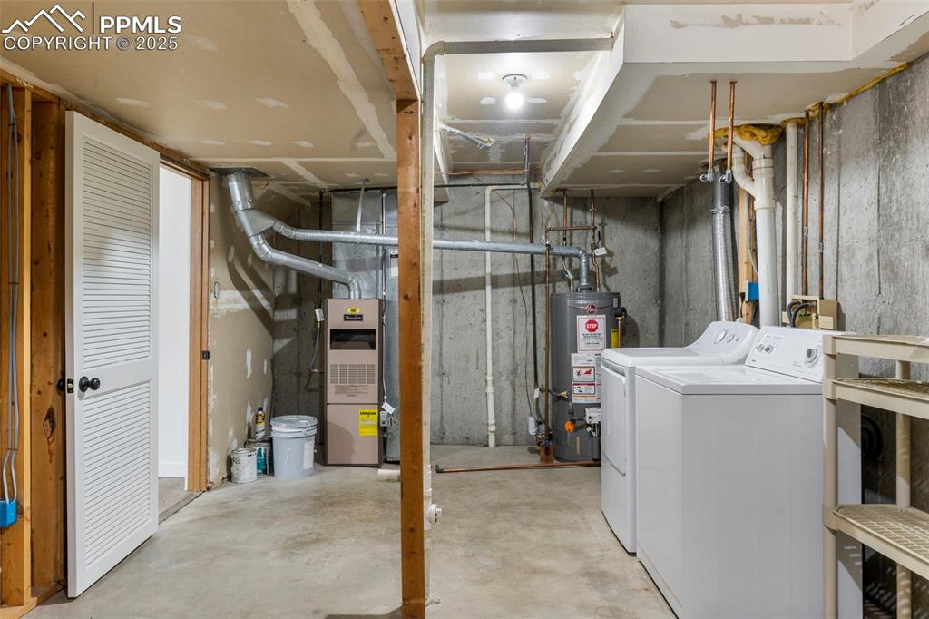 Image 22 of 24: Unfinished below grade area with washing machine and dryer and gas water he
