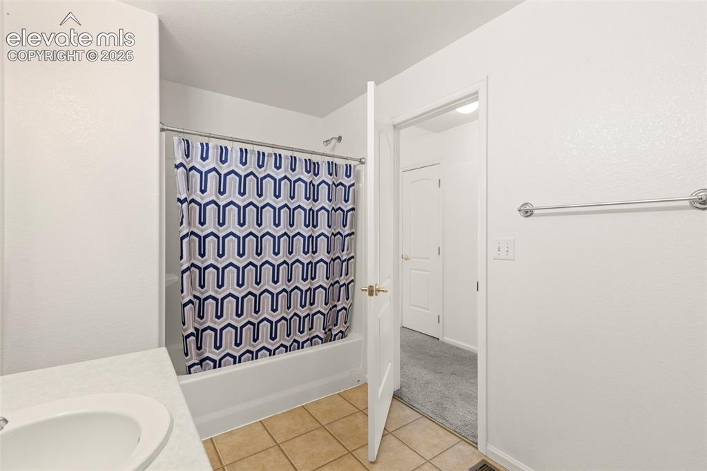 Image 11 of 22: Bathroom featuring a tub/shower combination with a chrome showerhead, a whi