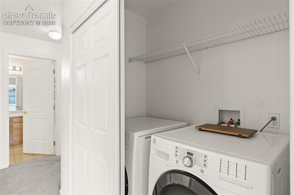 Image 13 of 22: Laundry closet featuring white bi-fold doors, upper wire shelving, and util