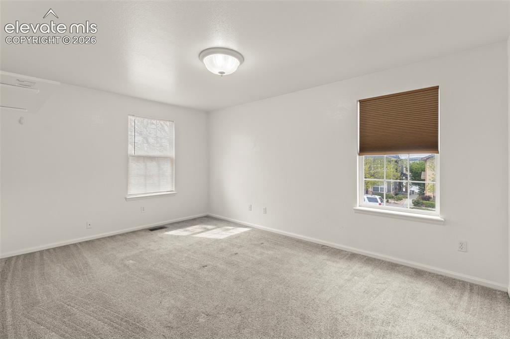 Image 14 of 22: Carpeted room featuring white walls, a ceiling-mounted light fixture, two w
