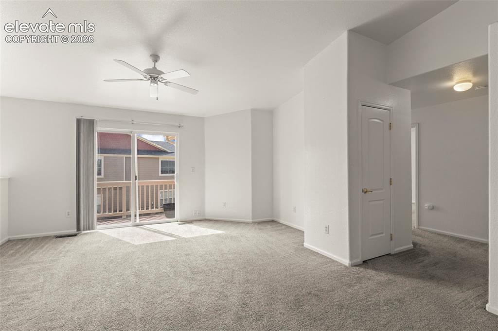Image 8 of 22: Spacious room with grey carpet flooring, light neutral paint, and an overhe