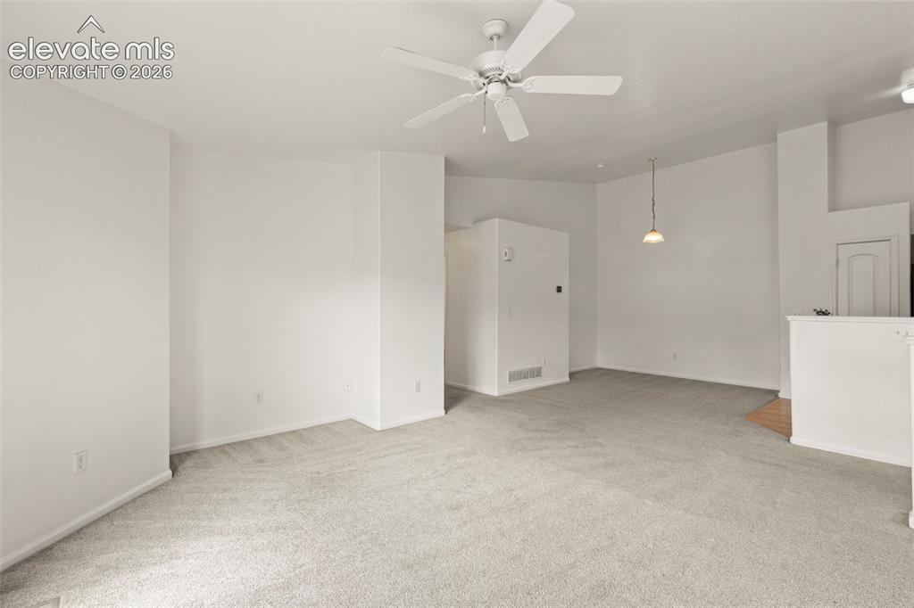 Image 9 of 22: Open-concept living space featuring light-colored carpeting, a ceiling fan,