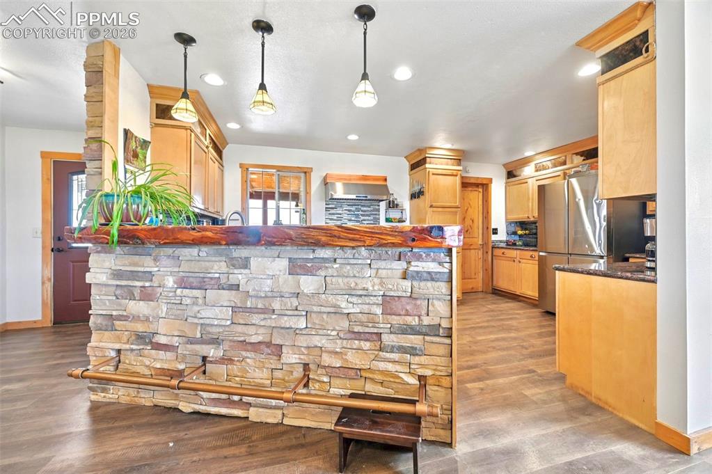 Image 7 of 34: Live-edge slab bar top with boot-rail