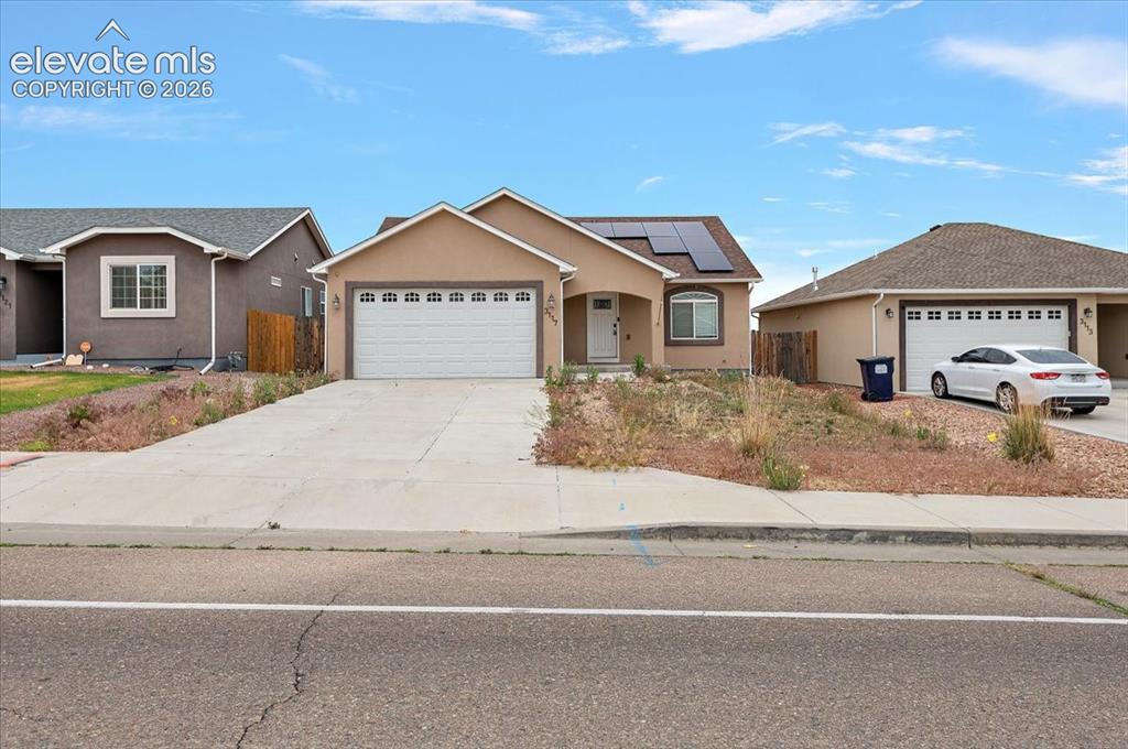 Image 1 of 21: Single-story residence featuring a tan stucco exterior, an attached two-car