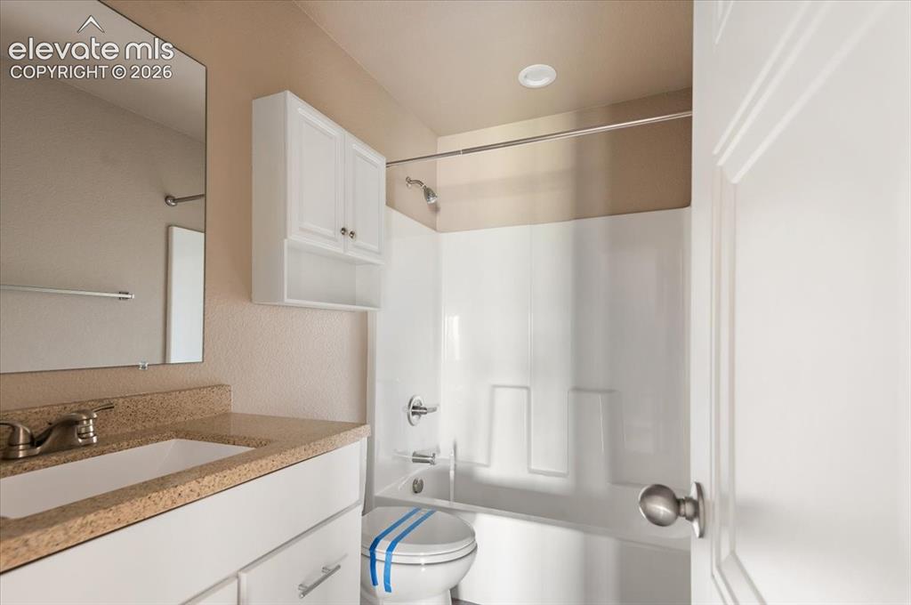 Image 14 of 21: Full bathroom featuring a white vanity with a light-colored countertop, an