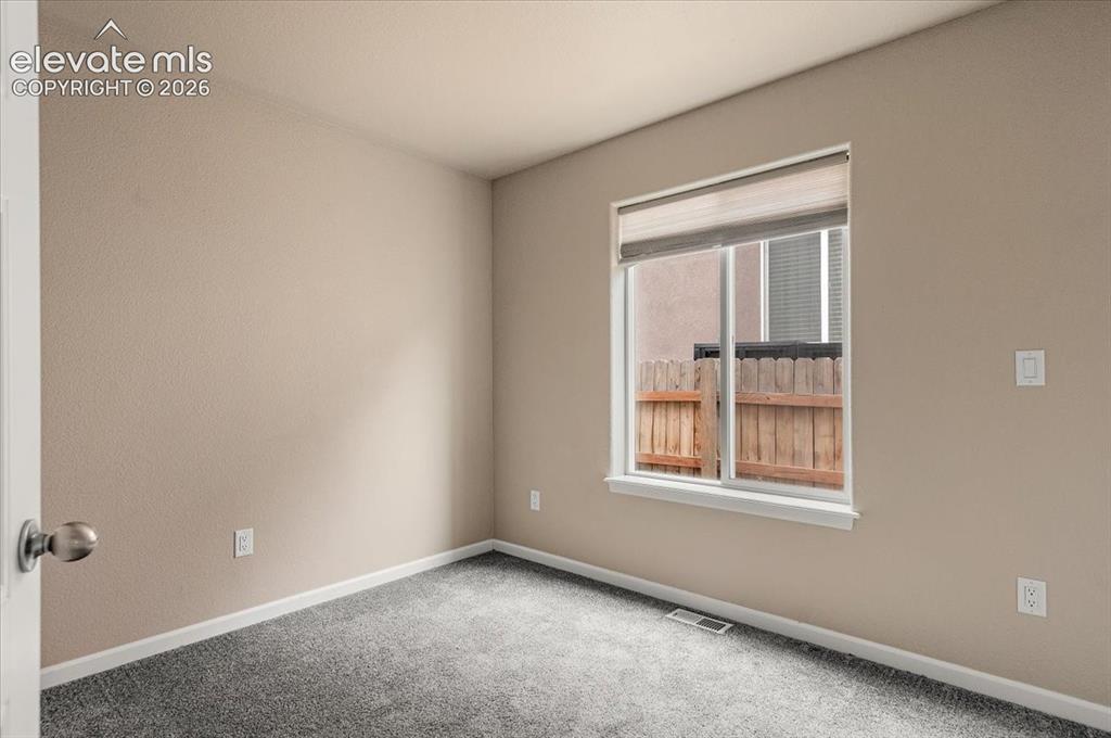 Image 15 of 21: Room featuring neutral-toned walls, a single window with blinds, and new ca