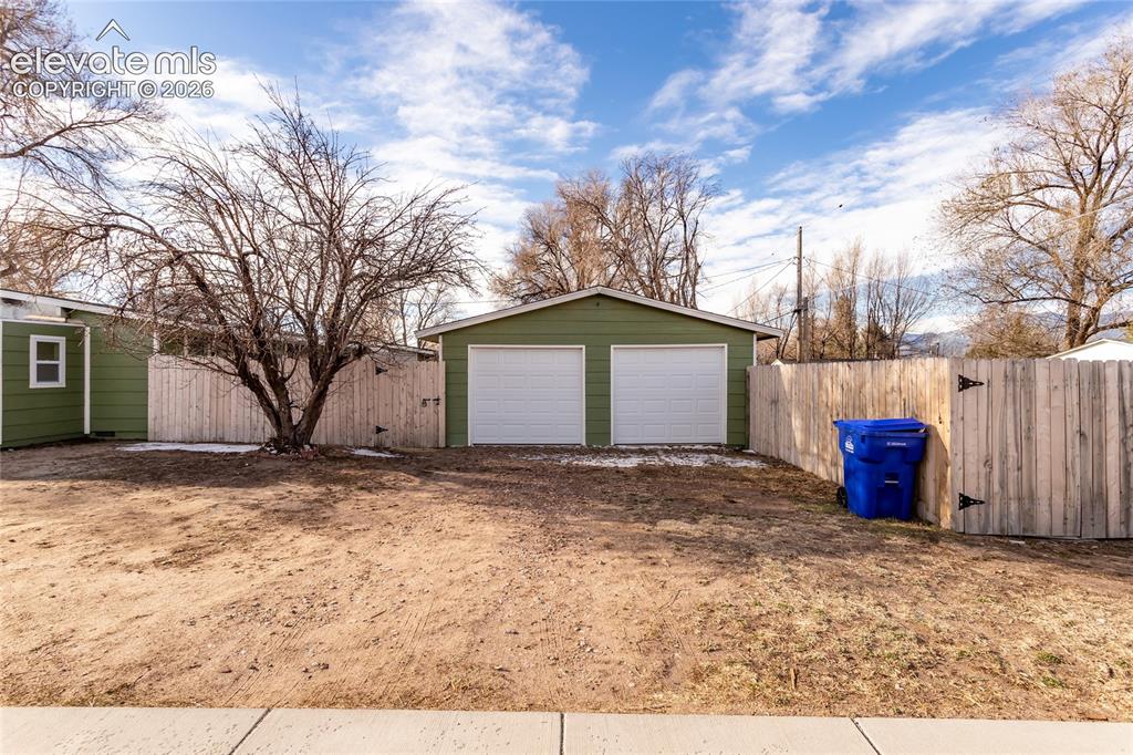 Image 33 of 40: 2 mini-car/motorcycle detached garage with bonus room at the back. 2 car pa