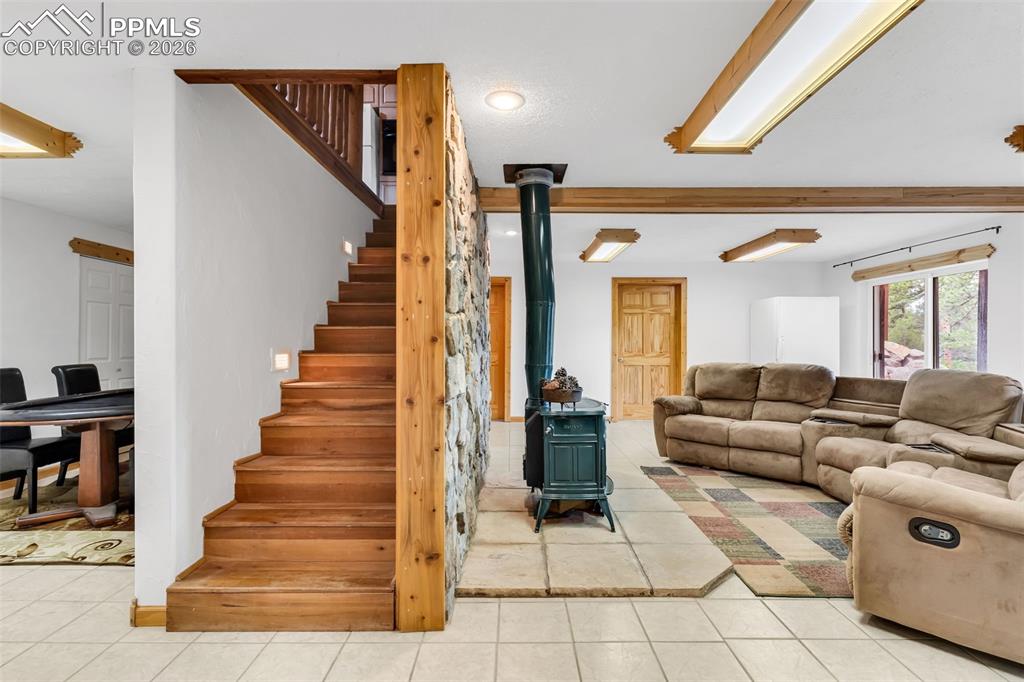 Image 30 of 49: The stairs separate the lower level game area (with tons of closet space) a