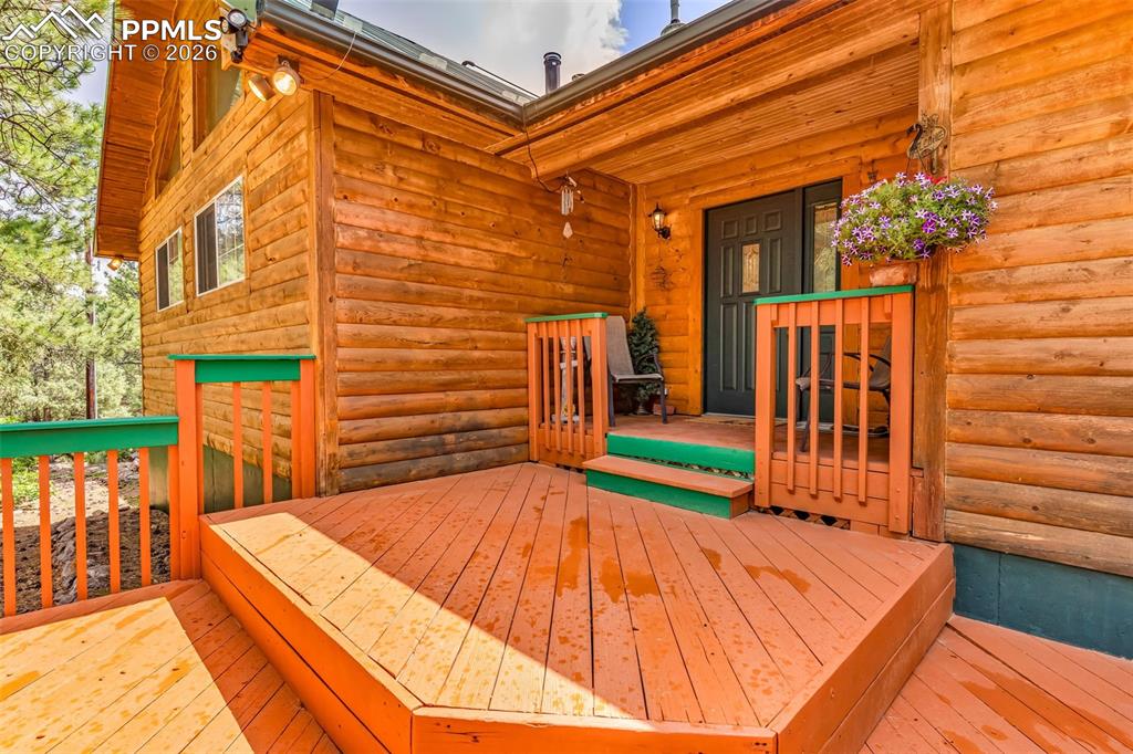 Image 7 of 49: Great front deck for enjoying the cool nights and afternoon shade