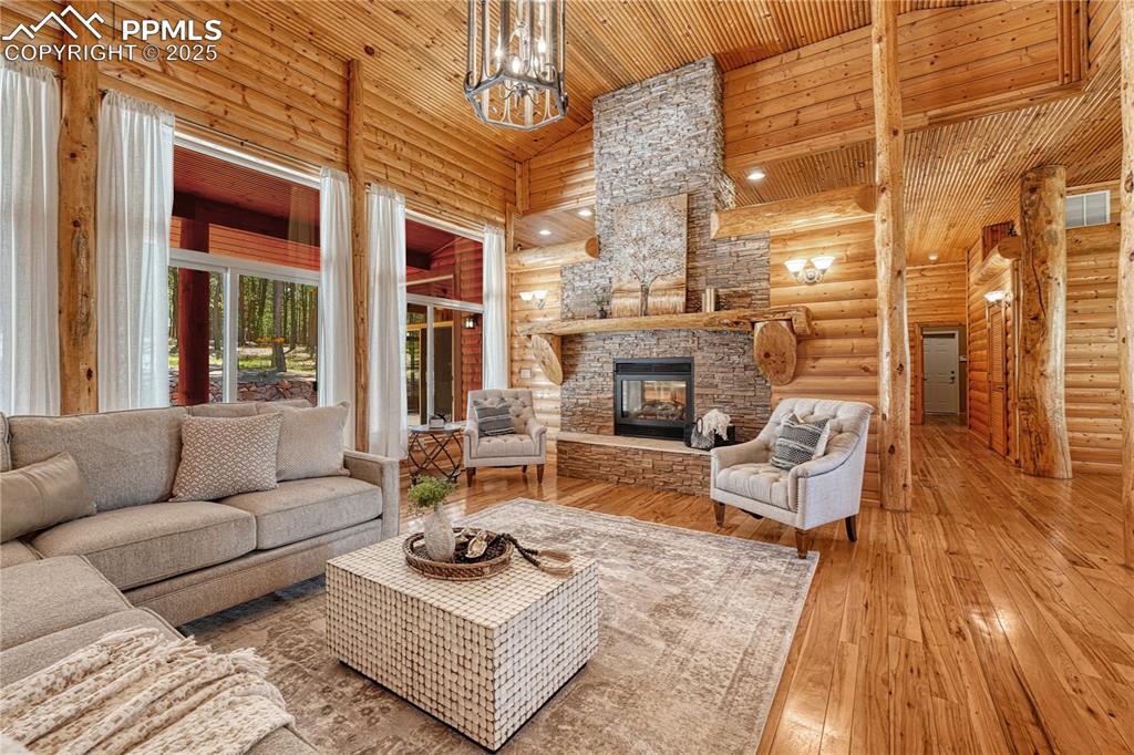 Image 11 of 50: Large gas log, pass-through fireplace accented by stacked stone and log man