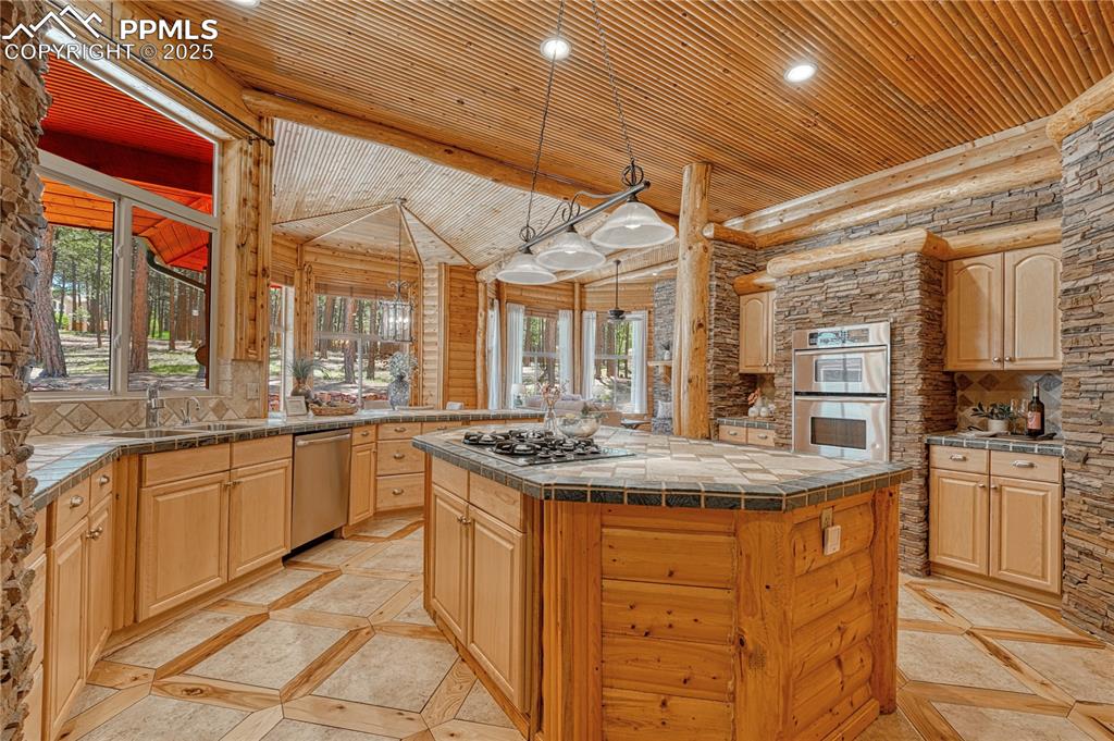 Image 12 of 50: Spacious rustic kitchen with custom wood & tile flooring features more stac