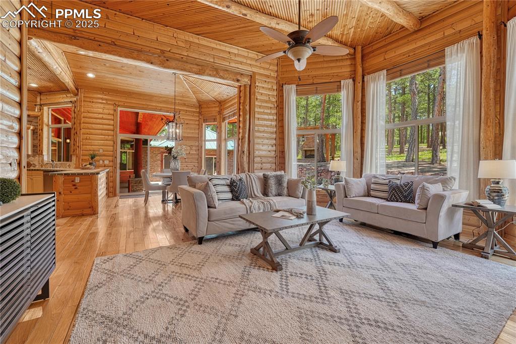 Image 17 of 50: Adjoining the dining nook is the great room with massive windows bringing n