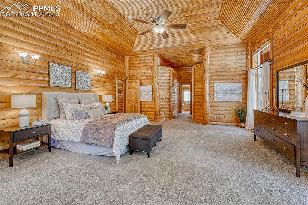 Image 24 of 50: A stunning Primary Suite with 10-foot high log walls and a handcrafted coff