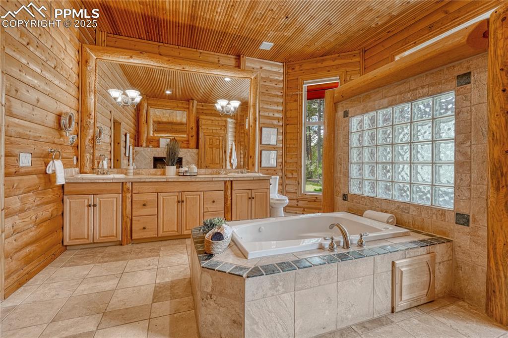 Image 26 of 50: 5-piece Spa Bath with travertine tile throughout