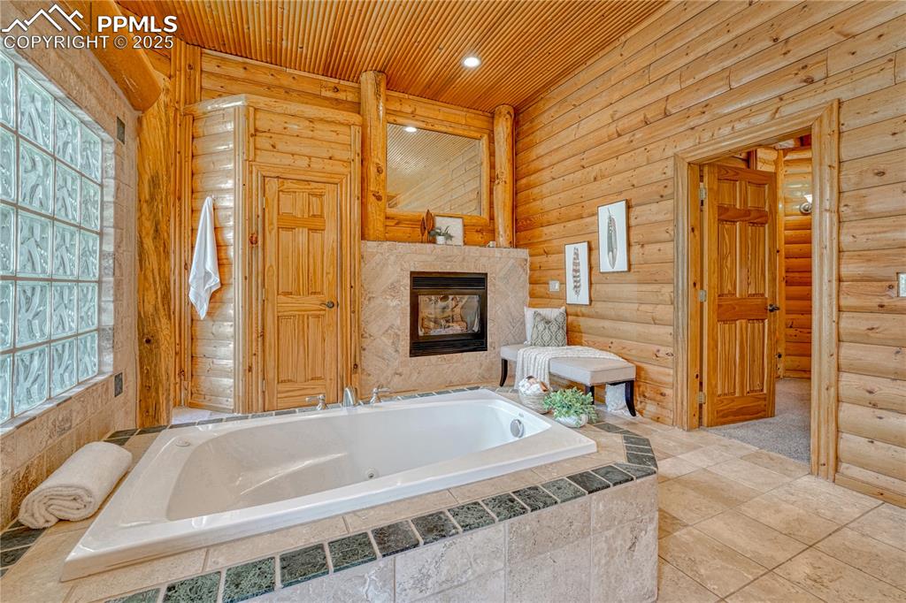 Image 28 of 50: After a long day, enjoy relaxing by the fireplace in a soothing tub bath