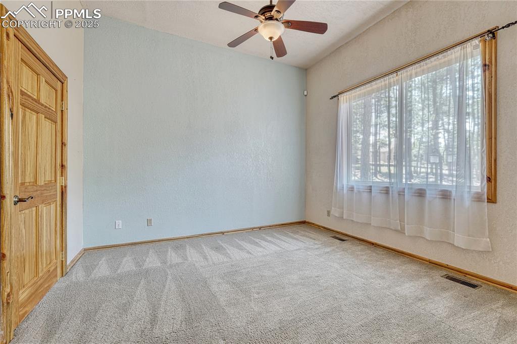 Image 32 of 50: Bedroom 3 is on the opposite side of the house and is carpeted and has vaul