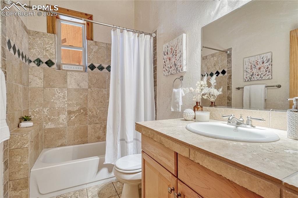Image 33 of 50: This is the ensuite full bathroom for BR3 with more natural travertine tile