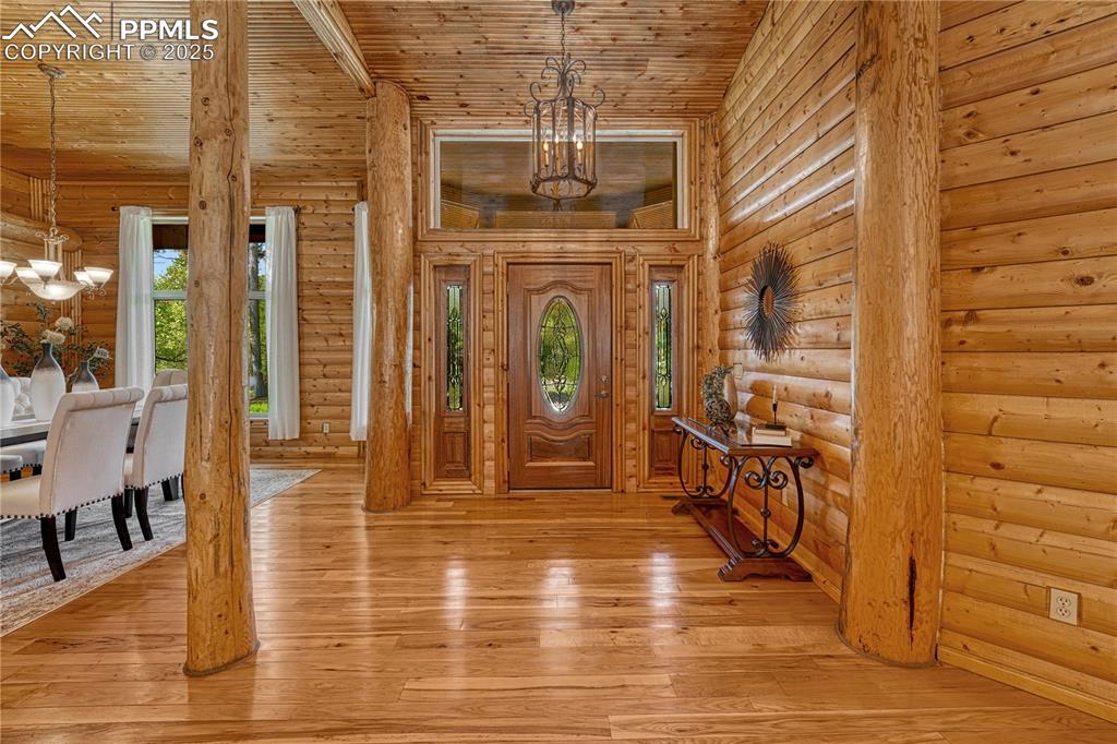 Image 7 of 50: The main entry opens up to an elegantly built log home with high ceilings