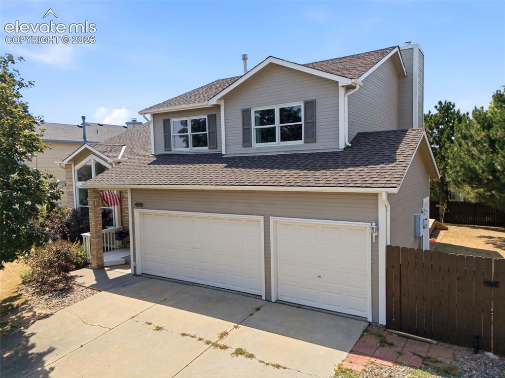 Image 1 of 50: Two-story residence with a two-car garage, gray siding, and a brown shingle