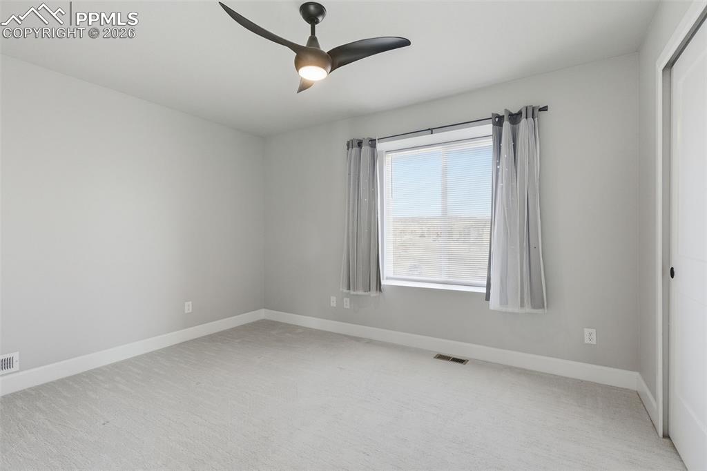 Image 28 of 47: 2nd spacious bedroom featuring light colored carpet and ceiling fan