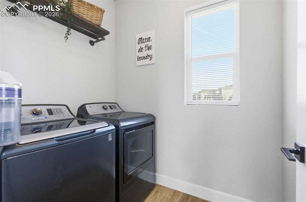 Image 36 of 47: Laundry area with light wood finished floors and washer and clothes dryer