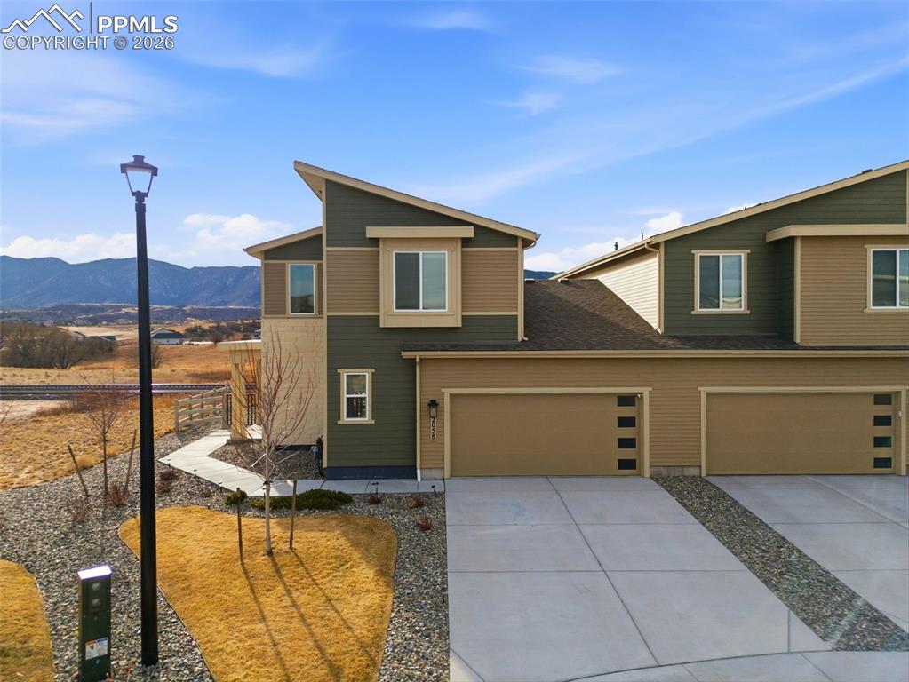 Image 44 of 47: View of front of home featuring driveway, a mountain view, and a garage