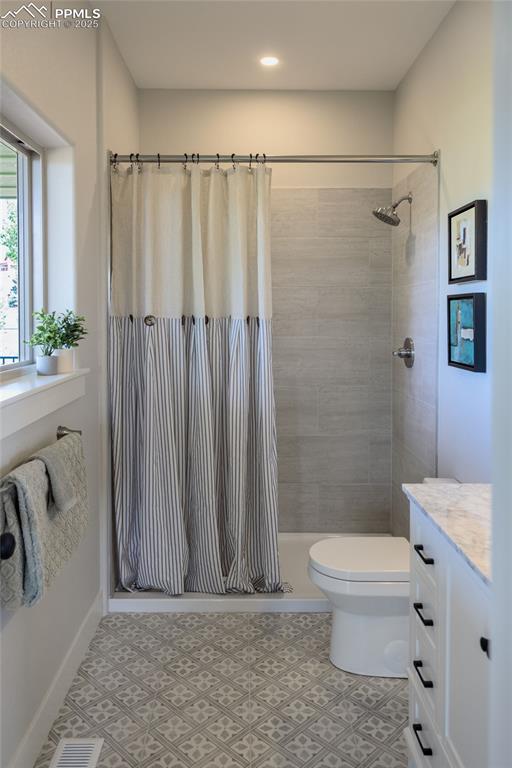 Image 14 of 21: Primary bathroom with a large porcelain tiled shower and vanity with porcel