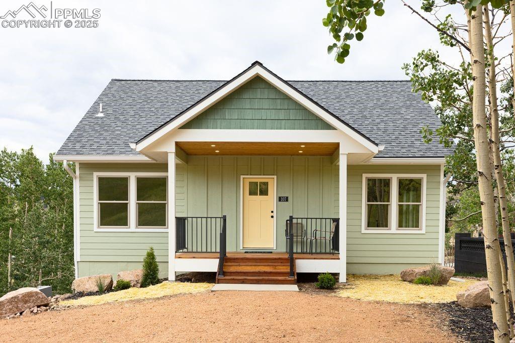 Image 2 of 21: Bungalow-style house with a shingled roof, covered porch, lap siding on the