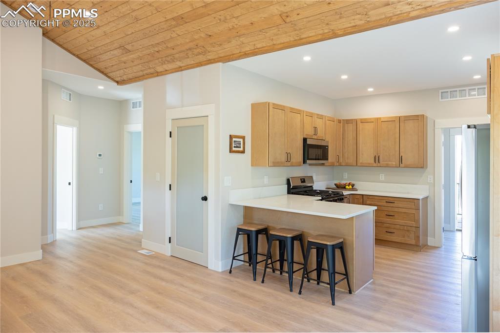 Image 6 of 21: Kitchen with recessed lighting, breakfast  bar, ample maple cabinets for to