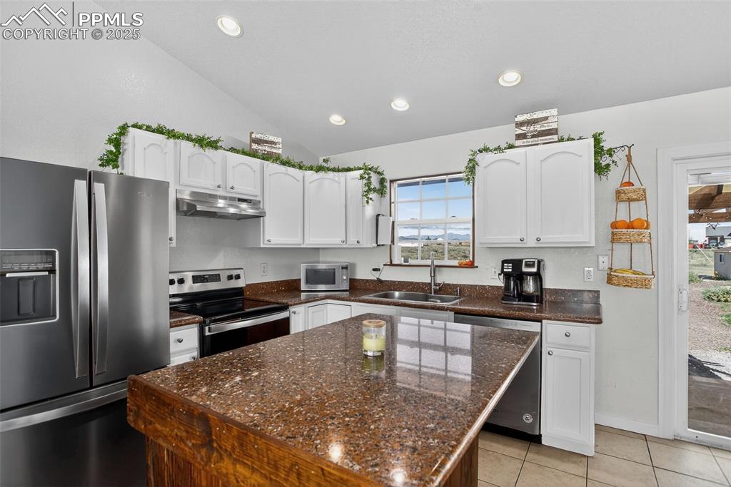 Image 15 of 50: with granite countertops and custom rolling island