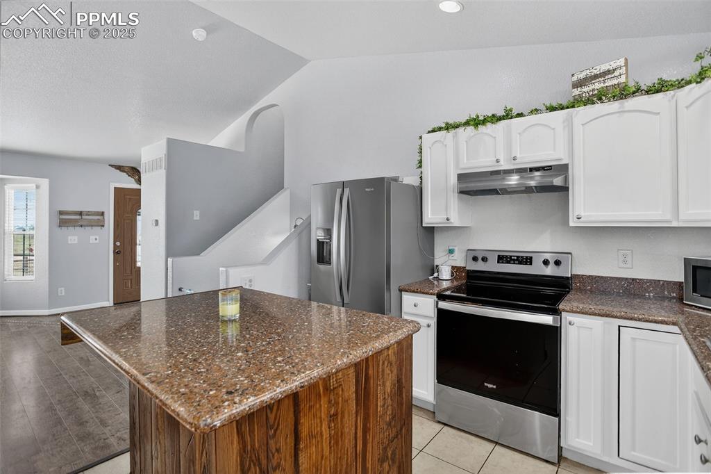 Image 16 of 50: with granite countertops and custom rolling island