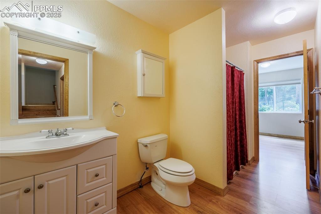 Image 15 of 32: Full bath featuring wood finished floors and vanity
