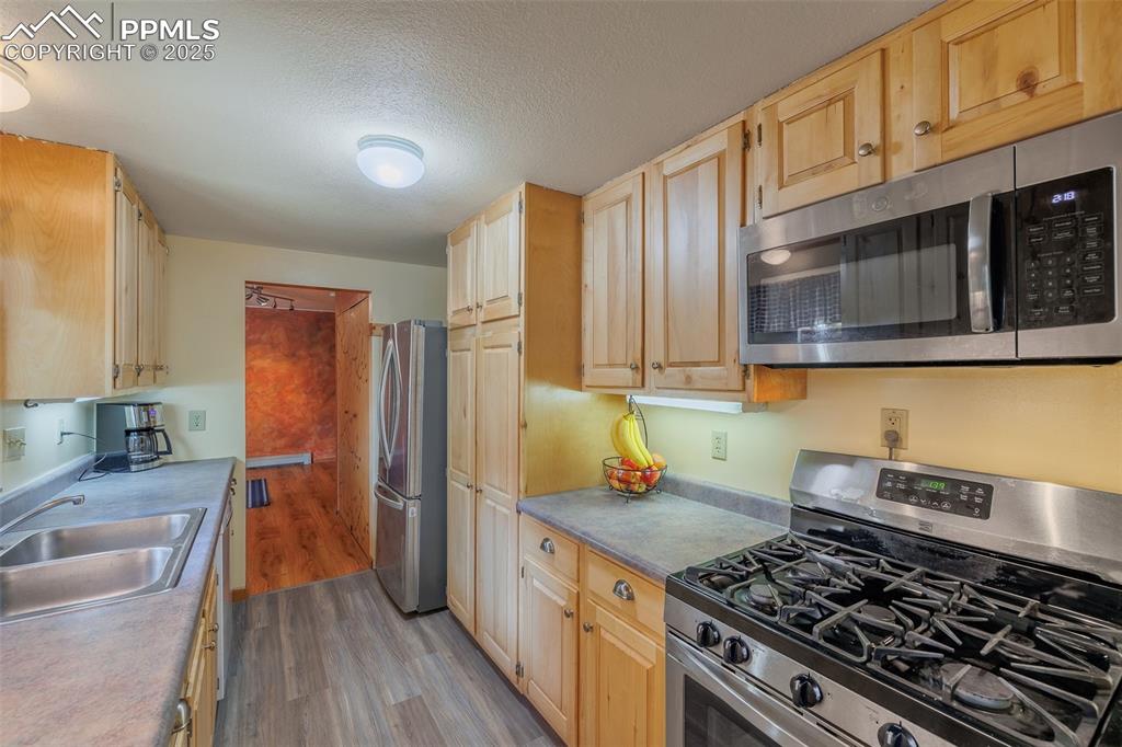 Image 9 of 32: Kitchen featuring stainless steel appliances, light wood-type flooring, lig
