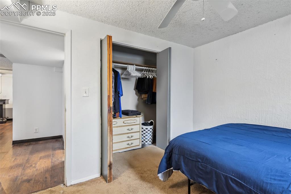 Image 16 of 20: Bedroom featuring a textured ceiling, a ceiling fan, a closet, baseboards,