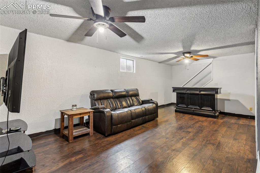 Image 18 of 20: Living area featuring a ceiling fan, hardwood / wood-style floors, a textur