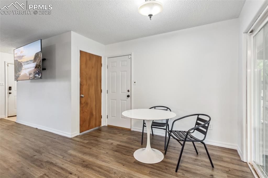 Image 5 of 20: Living area featuring wood finished floors, a textured ceiling, and baseboa