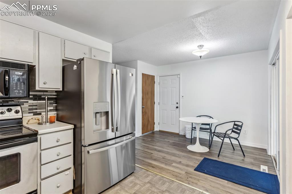 Image 7 of 20: Kitchen with stainless steel appliances, tasteful backsplash, white cabinet