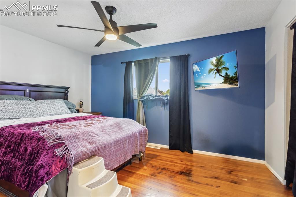 Image 8 of 20: Bedroom featuring baseboards, wood finished floors, and ceiling fan