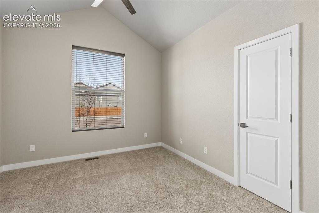 Image 13 of 40: Vaulted ceiling with integrated ceiling fan, neutral wall paint, carpeted f