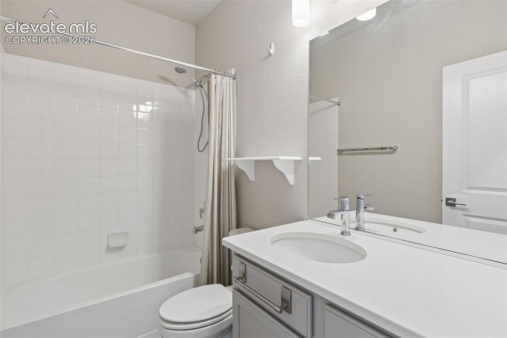 Image 14 of 40: Bathroom featuring a vanity with a white countertop and oval under-mount si