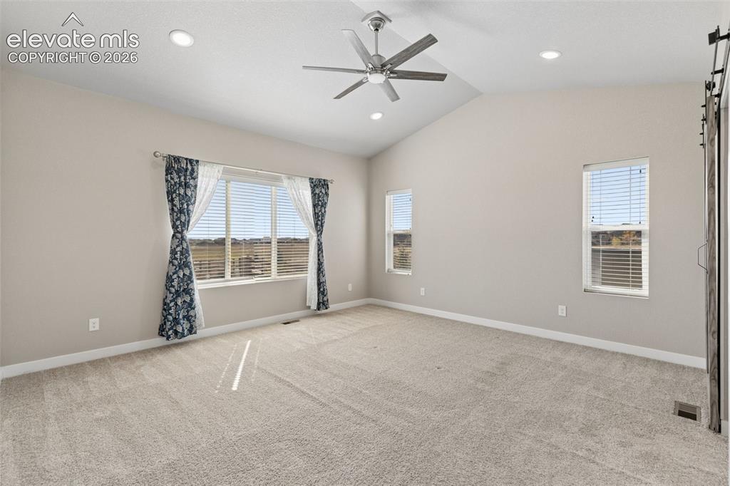 Image 15 of 40: Vaulted ceilings featuring recessed lighting and a brushed-metal ceiling fa