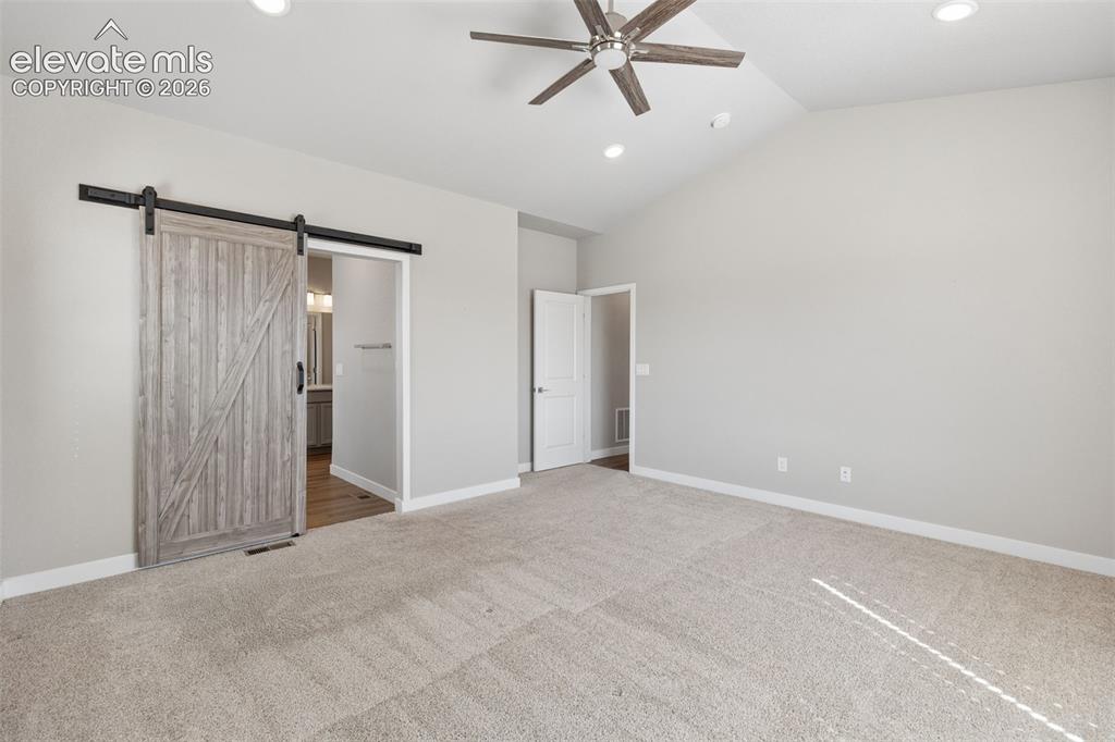Image 16 of 40: Vaulted ceiling featuring a central multi-blade ceiling fan, neutral wall-t
