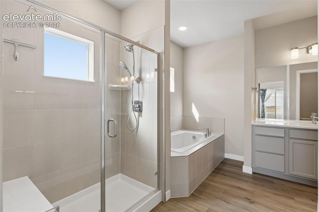 Image 17 of 40: Bathroom featuring a glass-enclosed shower with a built-in bench, a separat