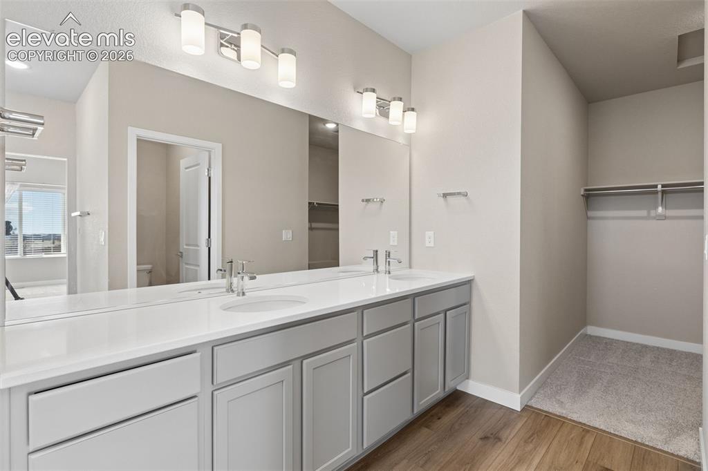 Image 18 of 40: Dual-sink vanity with a solid-surface countertop, full-width wall mirror, d
