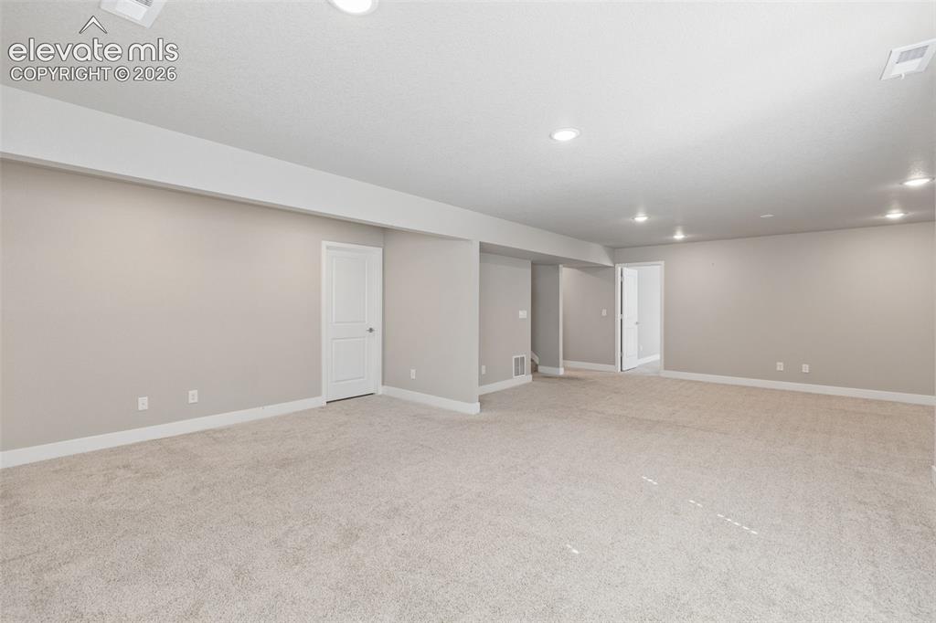 Image 22 of 40: Neutral-toned interior space featuring wall-to-wall carpeting, recessed cei