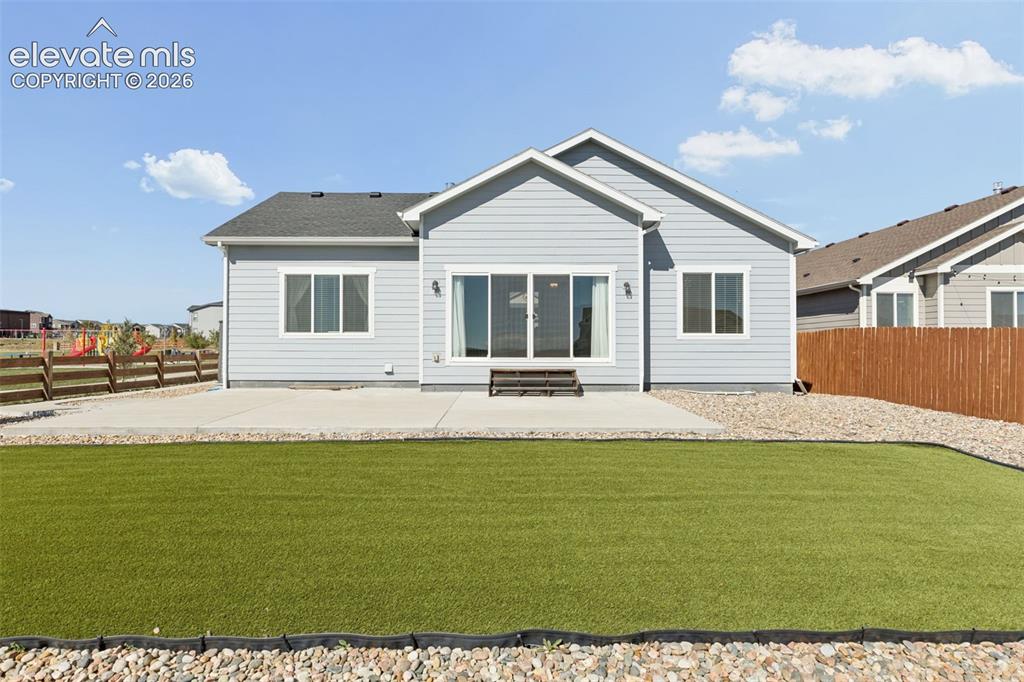 Image 28 of 40: Rear exterior featuring light blue horizontal lap siding, a concrete patio,