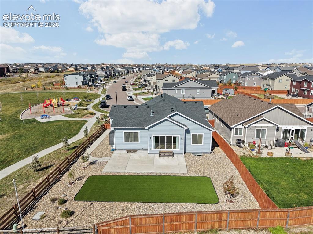 Image 34 of 40: Single-story residence featuring light-toned horizontal siding, dark-toned 